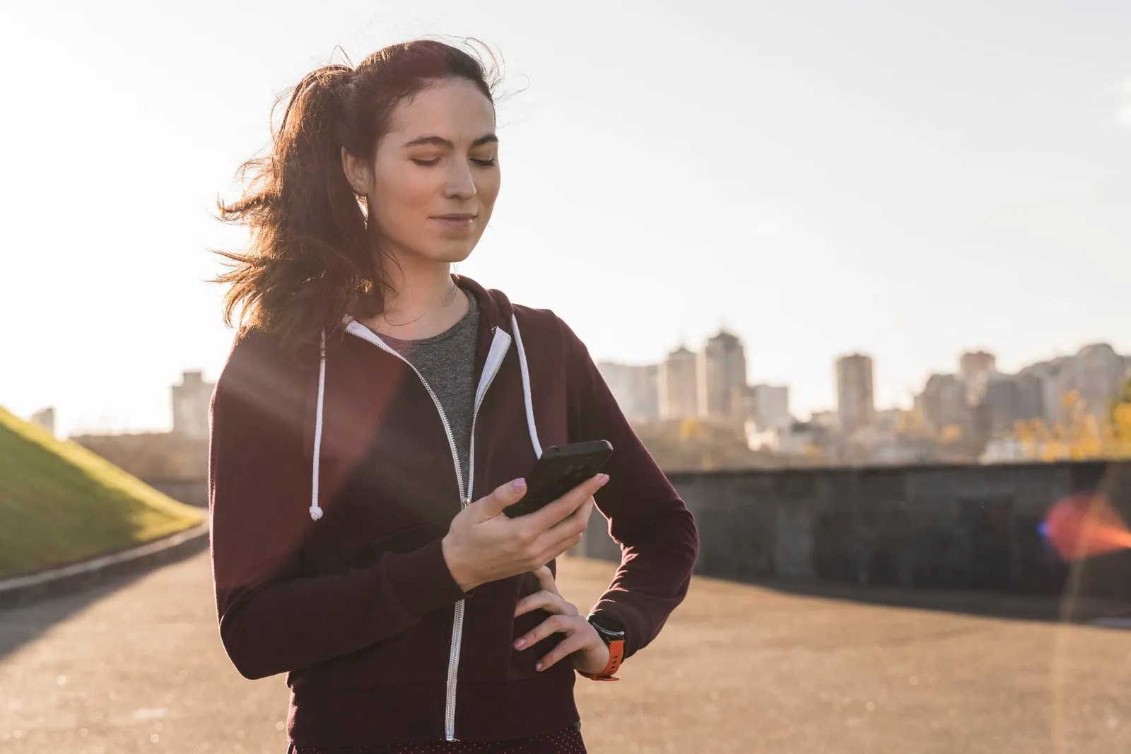 Mujer joven consultando el móvil tras hacer deporte
